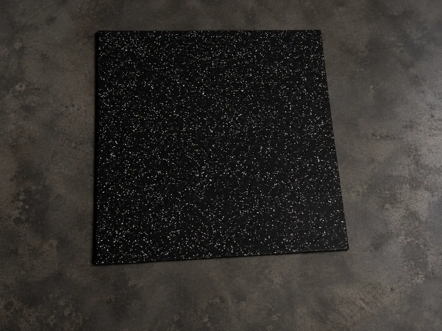 Placa de piso emborrachado preto com pontos claros, vista de cima.